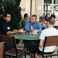 A group of people having a conversation around a table